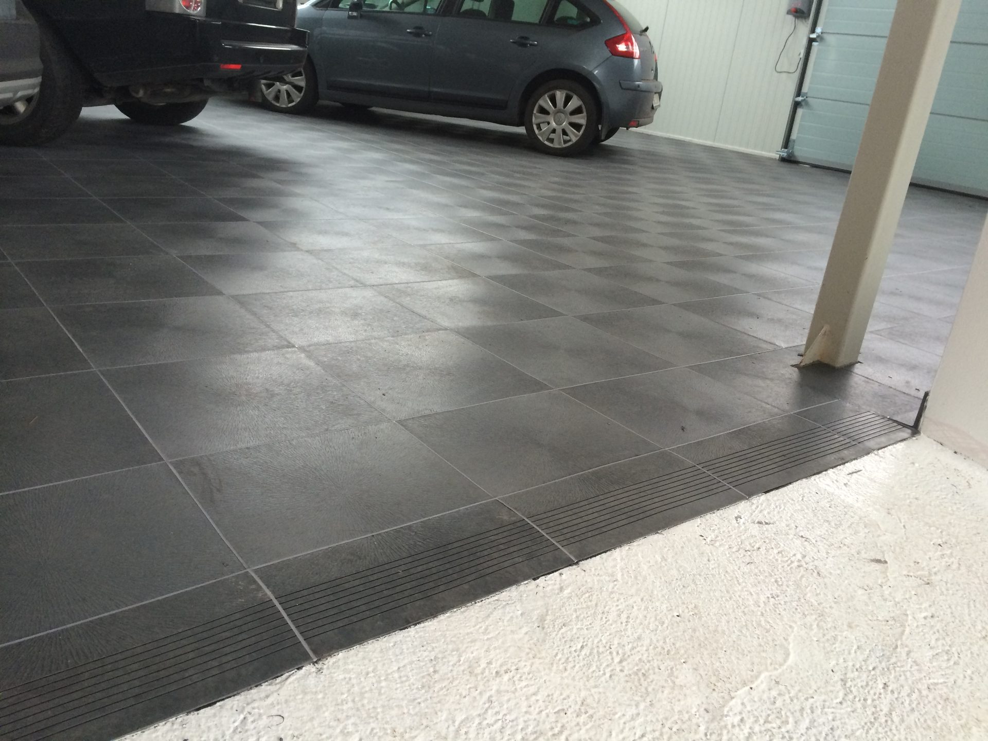 Tiefgarage mit Pkw auf dunkelgrauem Bodensystem