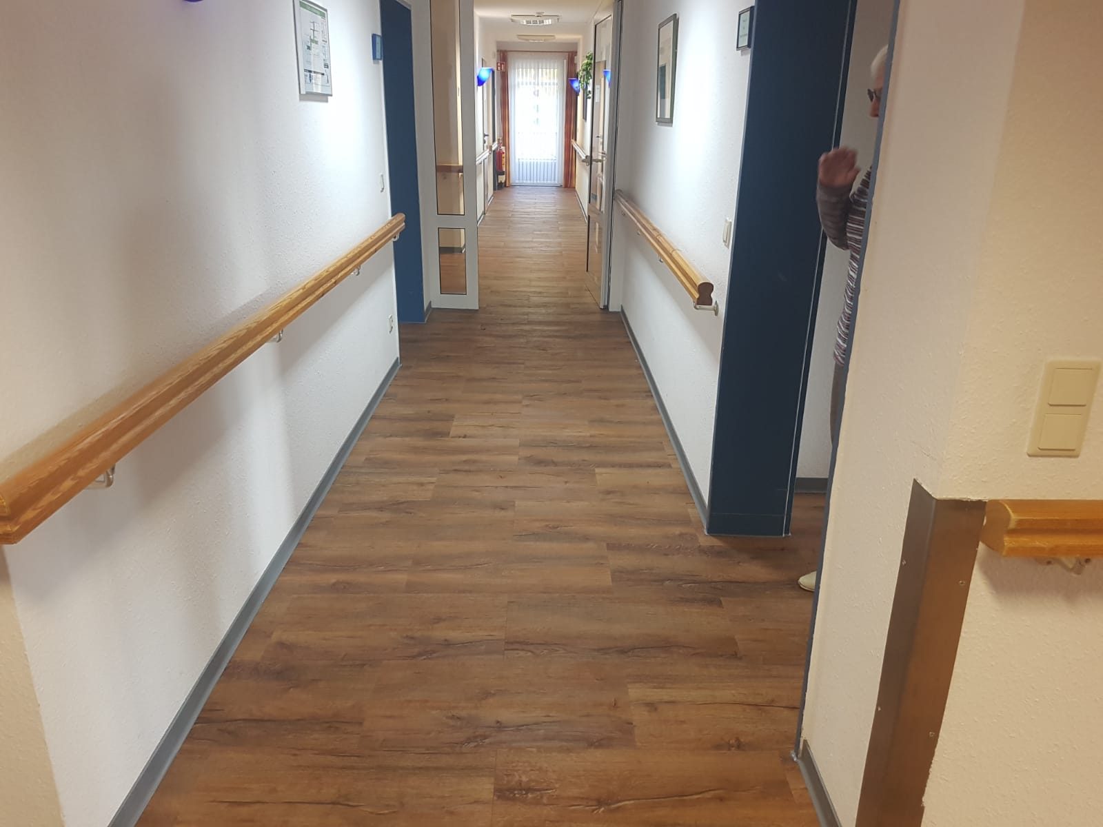 Flur mit Boden in Eichenoptik und Handlauf aus Holz