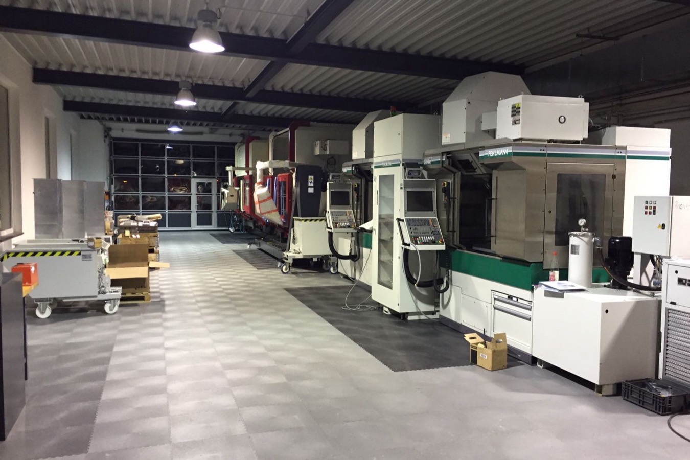 Produktionshalle mit CNC-Maschinen auf verlegtem Puzzle-Boden in Grau