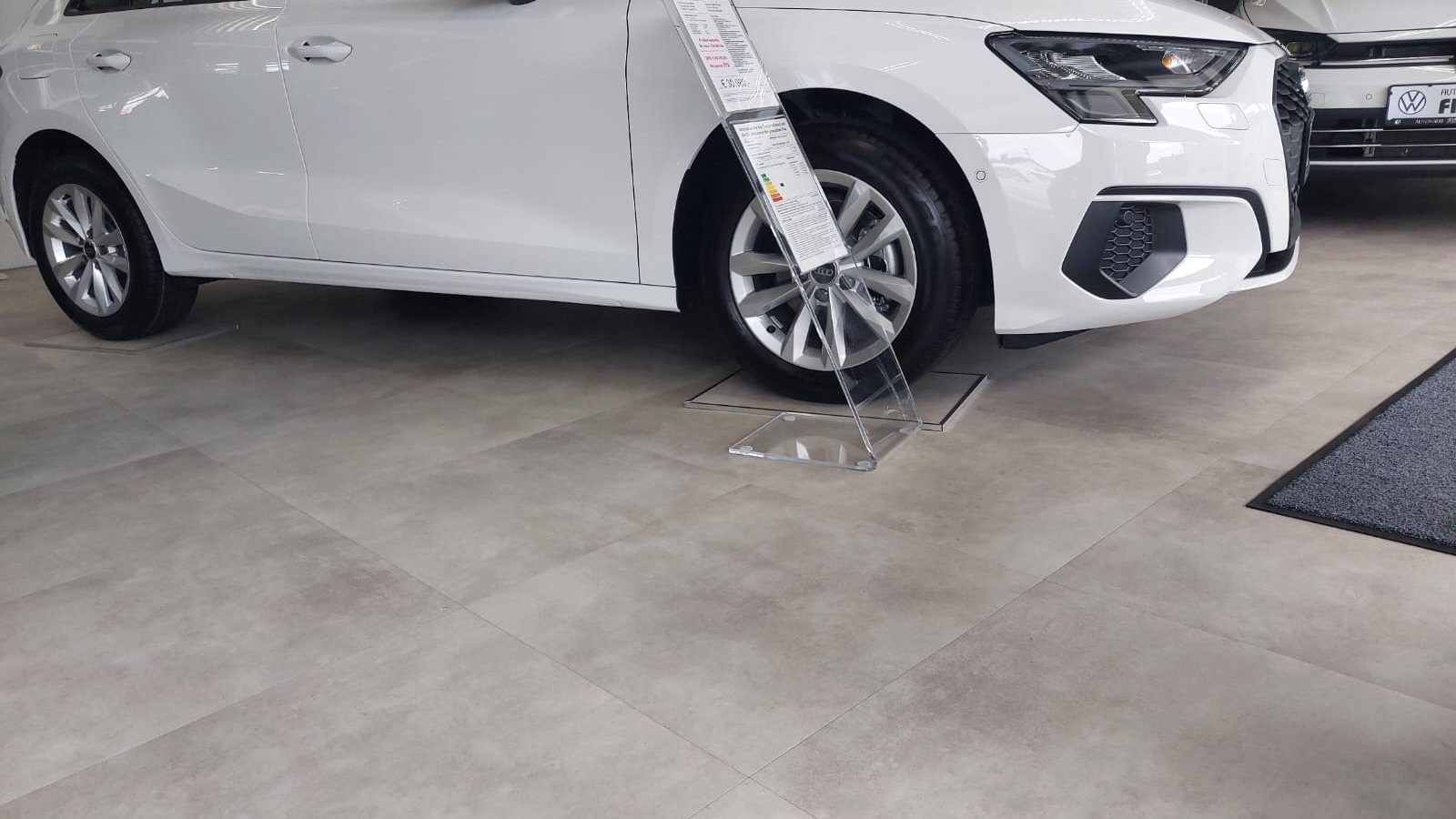 Fertiger Ausstellungsraum eines Autohauses mit Fahrzeug auf dem neuen Boden in Betonoptik